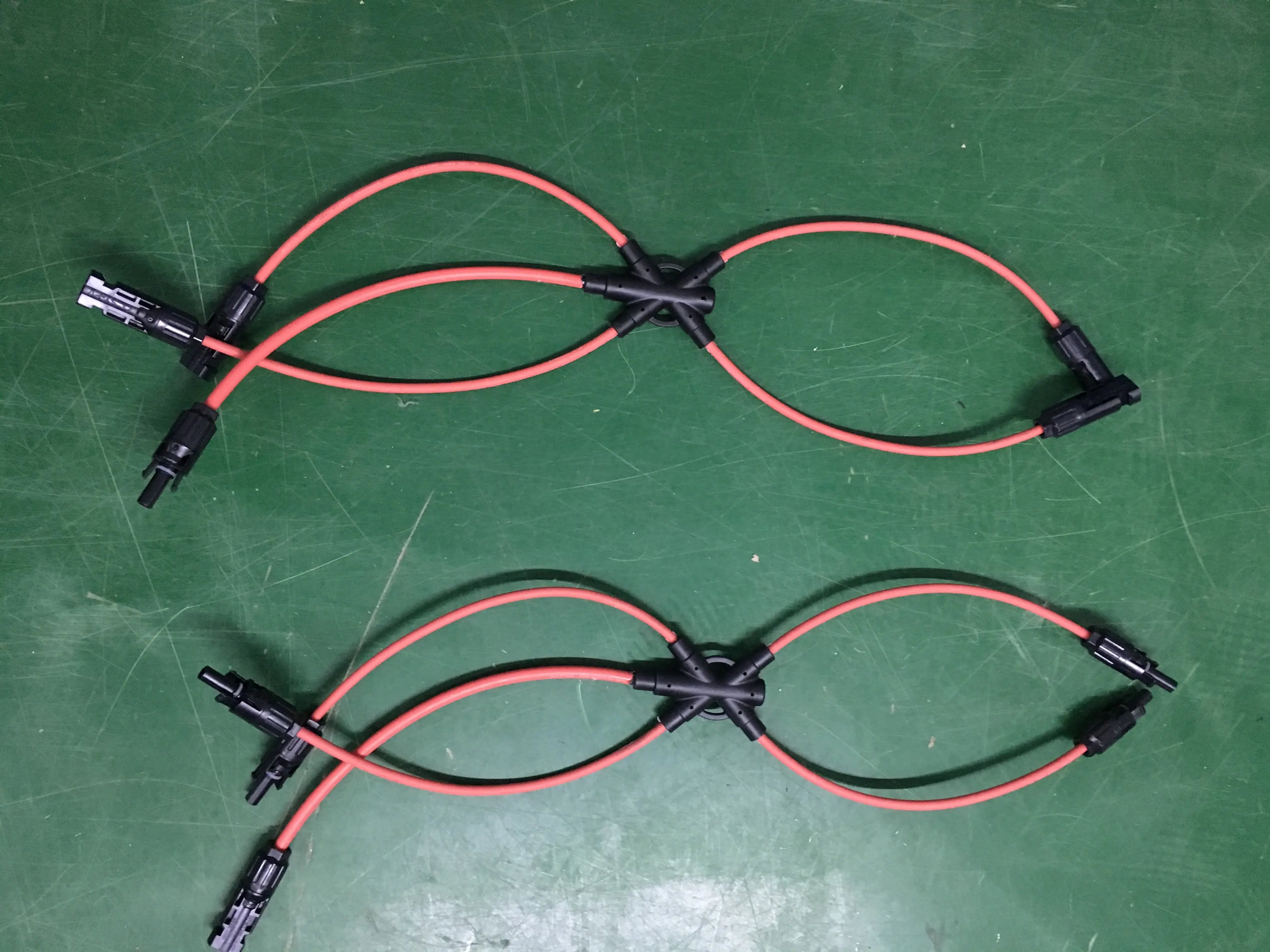 Red CM41-A 1000V DC solar PV 4-way branch connector with waterproof IP67 rating from PVconnectorpro on green work surface.